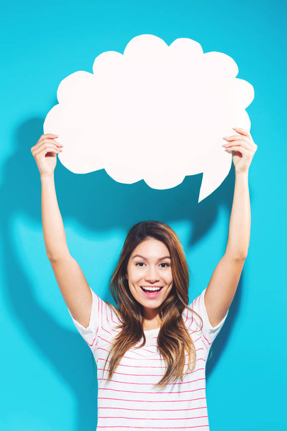 Young woman holding a speech bubble - Photo, image