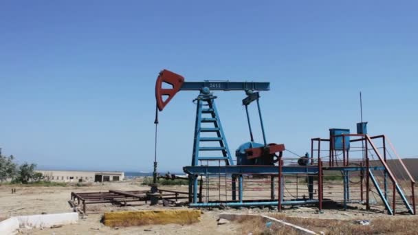 Ropné pumpjacks v práci ropné pole v Baku, Azerbaijan.Silhouette olejové čerpadlo na pozadí modré oblohy a mraky práce. Ropná pole - Záběry, video