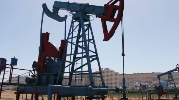 Ropné pumpjacks v práci ropné pole v Baku, Azerbaijan.Silhouette olejové čerpadlo na pozadí modré oblohy a mraky práce. Ropná pole - Záběry, video