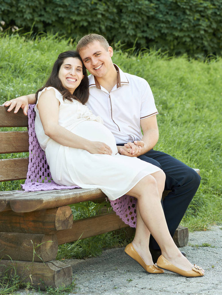 счастливая пара в летнем городском парке на открытом воздухе, беременная женщина, яркий солнечный день и зеленая трава, красивые люди портрет, желтый тонированный
 - Фото, изображение