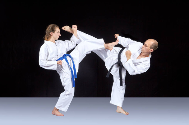 Athletes in karategi are training kicking in pairs - Foto, Bild