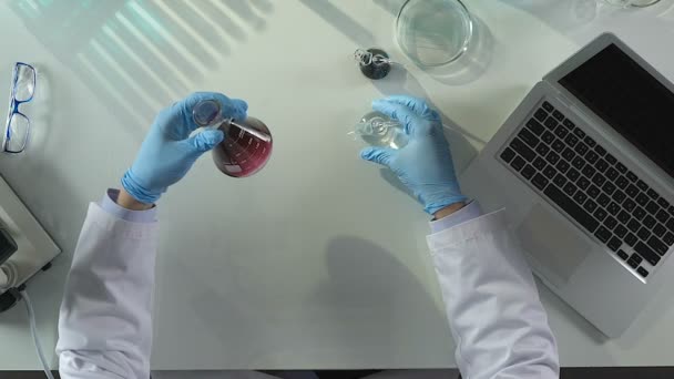 Assistente de laboratório realizando investigações para presença de sedimentos em líquido
 - Filmagem, Vídeo