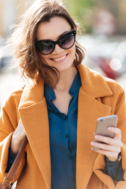 Happy smiling woman in sunglasses and coat - Fotoğraf, Görsel