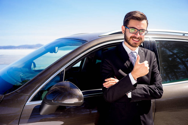 Man showing thumbs up near a car - Foto, Bild