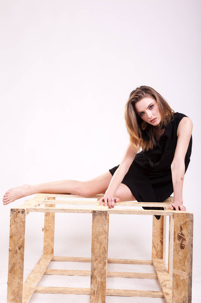 Donna sexy seduta su un pezzo di legno in studio foto
 - Foto, immagini