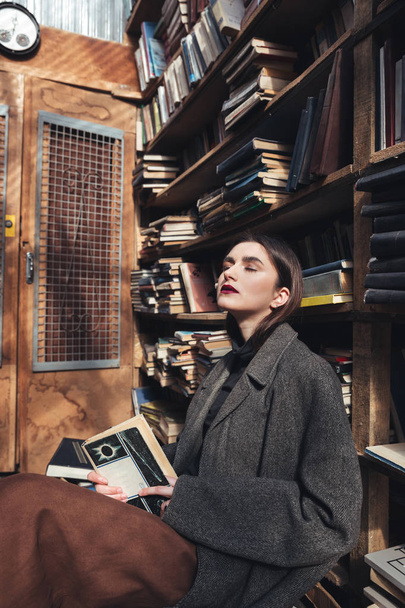 Portrait of a woman in coat holding book - Valokuva, kuva