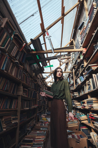 Girl standing in library with books - Zdjęcie, obraz