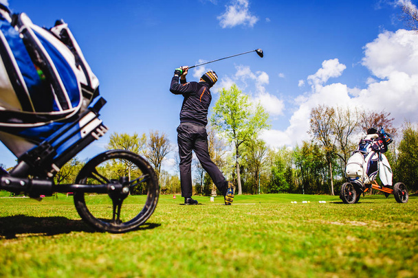 гравець в гольф потрапляє в м'яч
 - Фото, зображення
