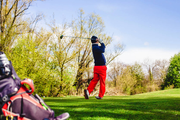 golfpelaaja lyö palloa
 - Valokuva, kuva