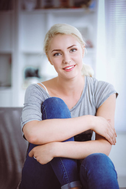 Young beautiful woman sitting on couch at her room - Foto, Imagem