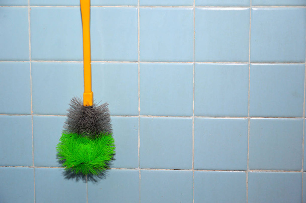 toilet brush hung on the wall blue ceramic tiles - Photo, Image