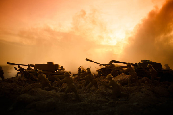 Concepto de guerra. Siluetas militares peleando escena en el fondo del cielo niebla de guerra, Soldados de la Guerra Mundial Siluetas debajo del horizonte nublado Por la noche. Escena de ataque. Vehículos blindados. Batalla de tanques
 - Foto, imagen