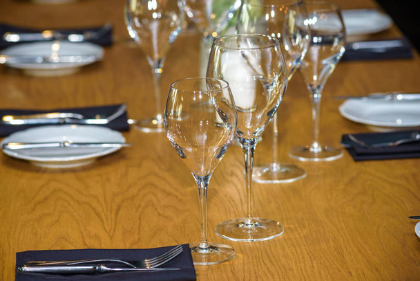 Beyaz masa örtüsü ile servis edilen boş restoran masası. - Fotoğraf, Görsel