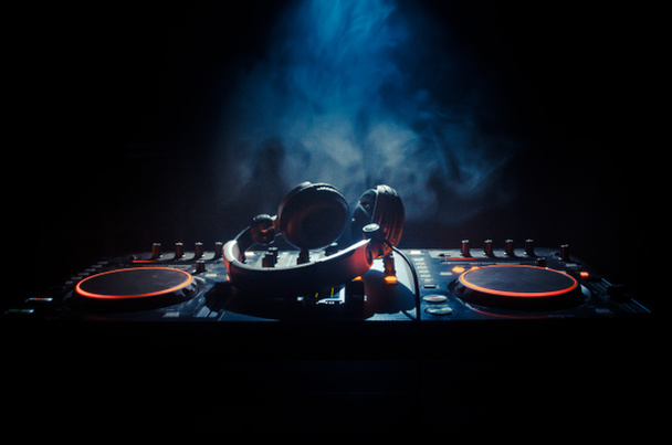 DJ Spinning, Mixing, e Scratching in a Night Club, Mãos de dj ajustam vários controles de pista no deck do dj, luzes estroboscópicas e nevoeiro, foco seletivo
 - Foto, Imagem