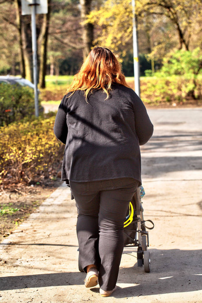 Sized mother walking with baby stroller - 写真・画像