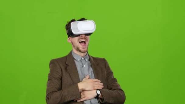 Businessman with virtual glasses looks funny video laughs. Green screen - Video