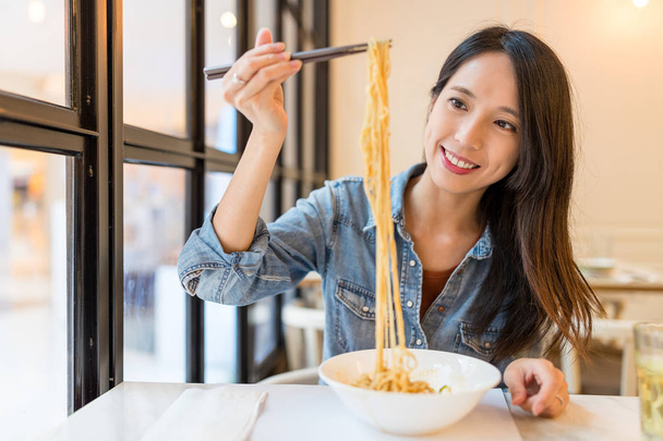 Woman eating noodles in chinese restaurant - Foto, Imagen