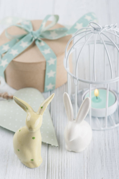Mint green lit candle in white lantern with gift  - Фото, изображение