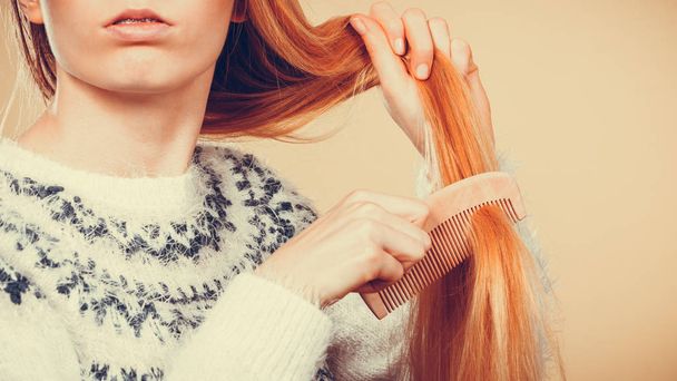 Teenage blonde girl brushing her hair with comb - Foto, afbeelding