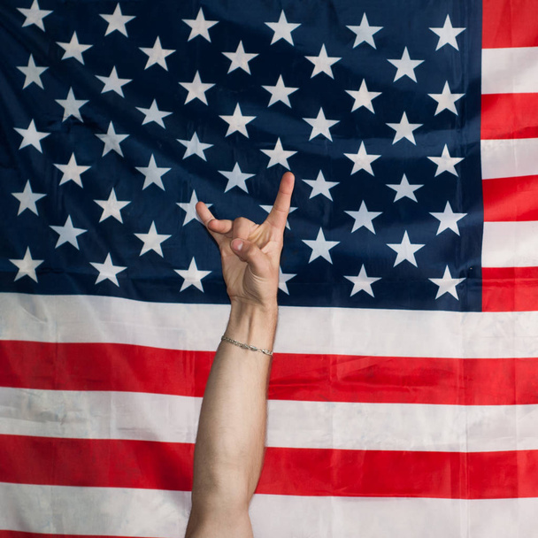 rock n roll en el fondo de la bandera americana, gesto con las manos
 - Foto, imagen