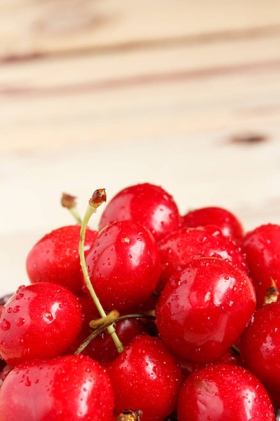 Red ripe juicy sweet cherry lies on vintage wooden background. Sweet summer berries. - Фото, зображення