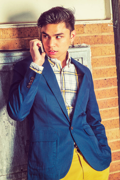 Nuori aasialainen amerikkalainen mies puhuu matkapuhelimella ulkona New Yo
 - Valokuva, kuva