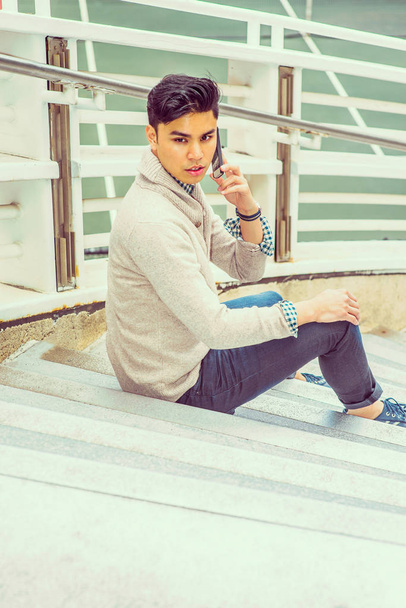 新しいヨーヨーの外で携帯電話で話している若いアジア系アメリカ人男 - 写真・画像