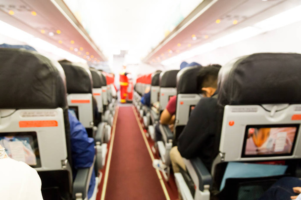 Häiriintynyt lentokoneen matkustamon sisustus istuimineen ja matkustajineen
 - Valokuva, kuva