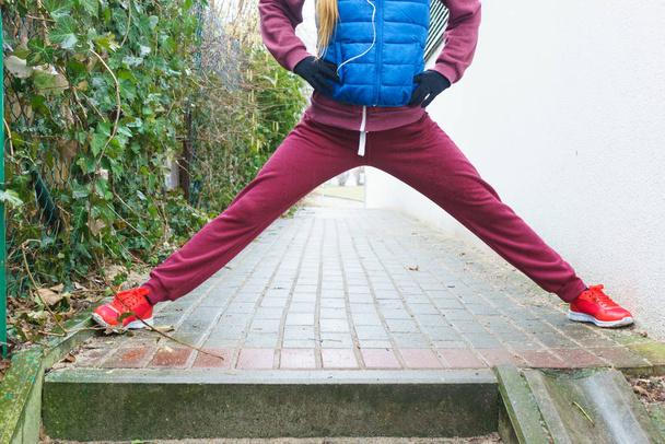 Woman wearing sportswear exercising outside during autumn - Photo, Image