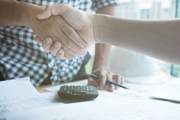 Architect and customer shaking hands at workplace. Engineer hand - Φωτογραφία, εικόνα