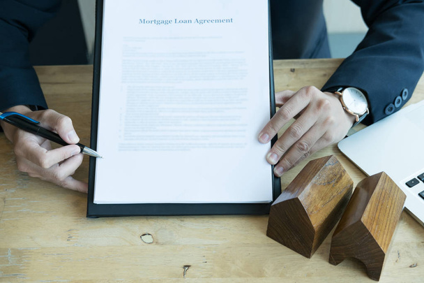 O agente imobiliário mostra o contrato de empréstimo hipotecário ao cliente. imobiliário
 - Foto, Imagem