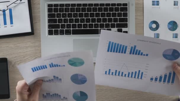 Büroleiter vergleicht statistische Berichte über das Eintippen von Daten in Laptops - Filmmaterial, Video