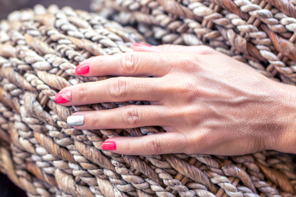Primer plano de las manos de una joven con manicura roja sobre clavos sobre fondo de madera
. - Foto, Imagen