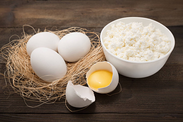 Dairy products on wooden table. Cottage cheese, egg and egg yolk. Top view with copy  - Photo, Image