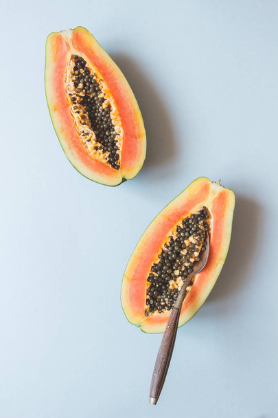 Fresh ripe papaya with spoon on the blue background, top view - Foto, Imagem