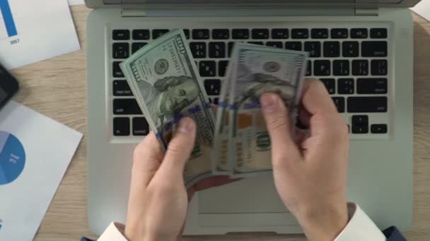 Close-up of businessperson counting dollar banknotes at workplace, slow-motion - Video