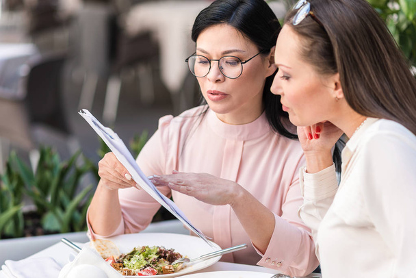Calm women choosing dish at table - Valokuva, kuva