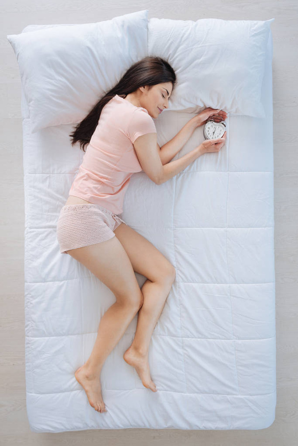 Potěšen, pěkná žena držící budík - Fotografie, Obrázek
