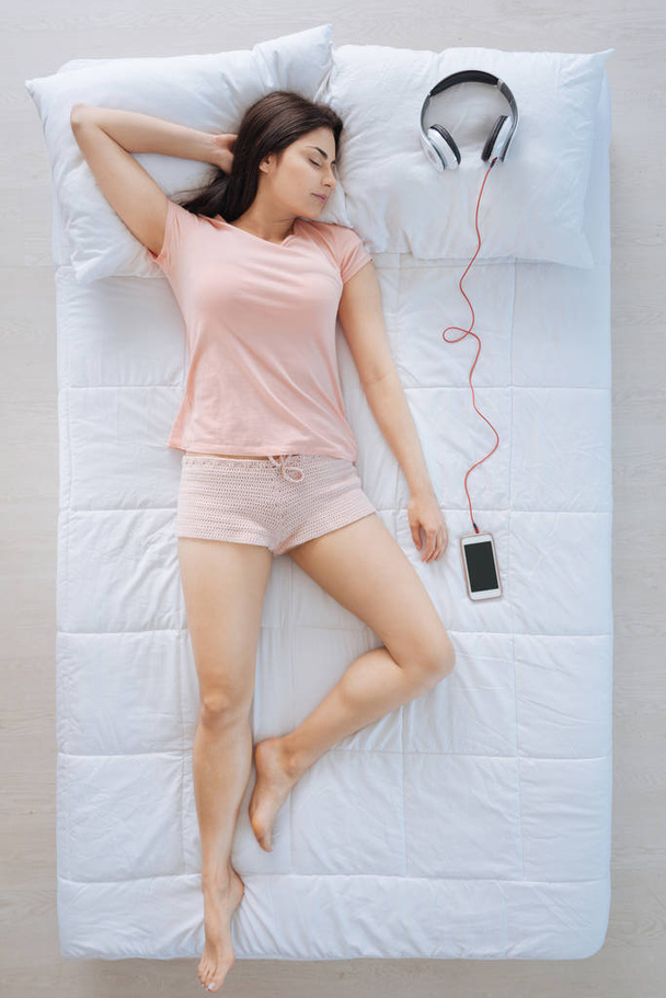 Calm relaxed woman lying near the headphones - Photo, image