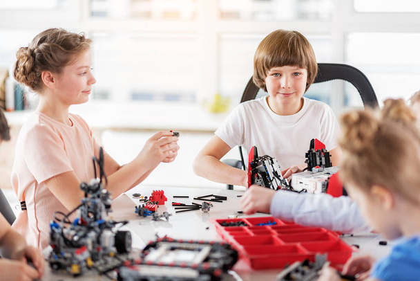 Curious smiling children making technical toys - Photo, Image