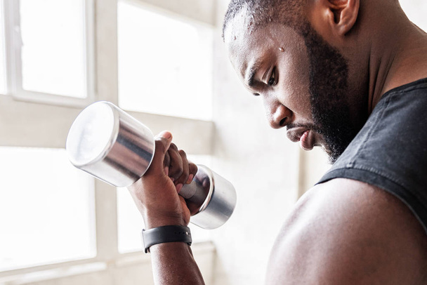 Pensive sporty african guy training his body muscles - 写真・画像