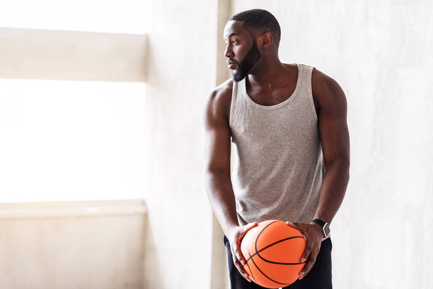Pensive muscular african man playing basketball - Foto, afbeelding