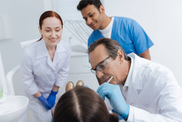 Competent dentist while filling teeth - Fotografie, Obrázek