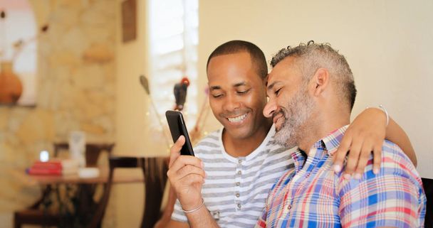 Couple gay heureux utilisant les médias sociaux sur le téléphone mobile
 - Photo, image