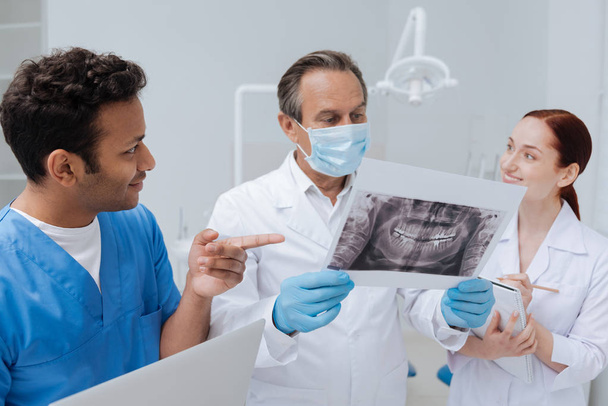 stomatologue attentif regardant la photo de rayons X de la mâchoire
 - Photo, image