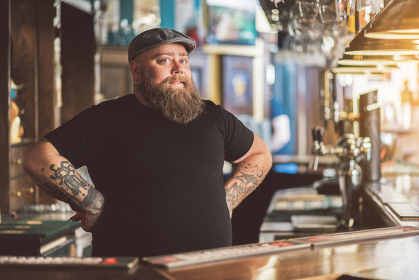Tattooed barman working in pub - Foto, Imagen