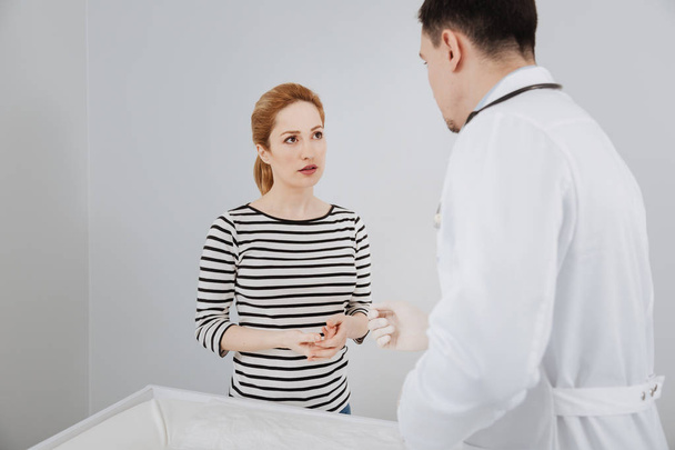 Clever worried woman asking physician for advice - 写真・画像