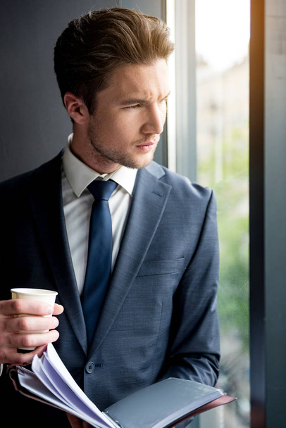 Pensativo hombre elegante en traje está descansando con café
 - Foto, Imagen