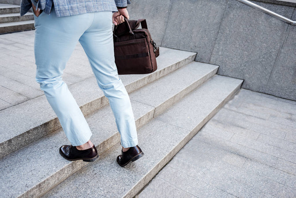 Active elegant male person overcoming stairs - 写真・画像
