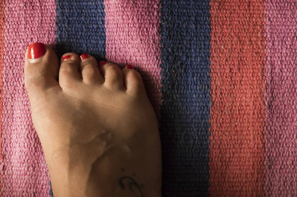 Piede della donna con tappeto colorato sullo sfondo
 - Foto, immagini